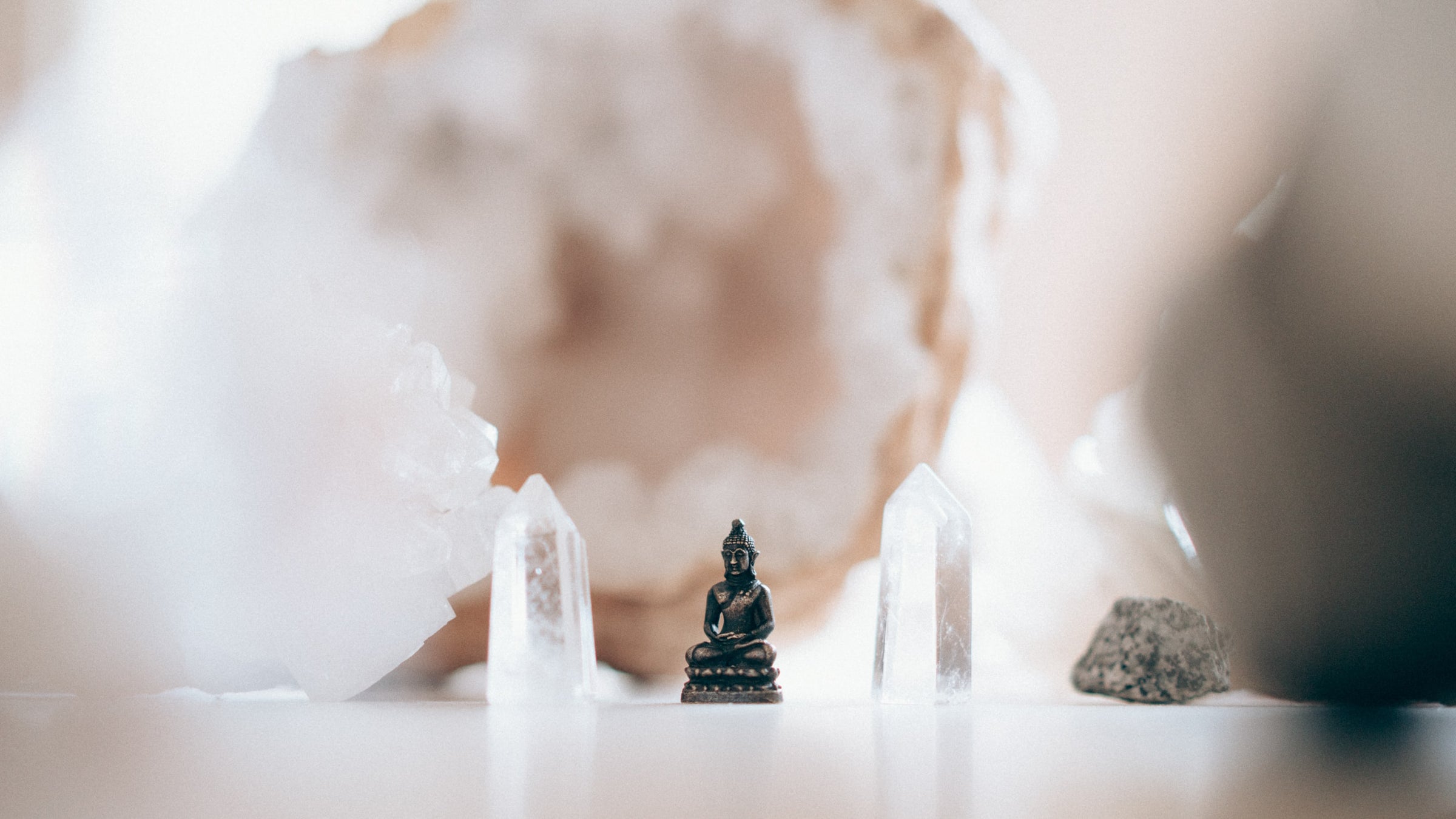 Clear quartz points arranged around a brown Buddha statue in the centre