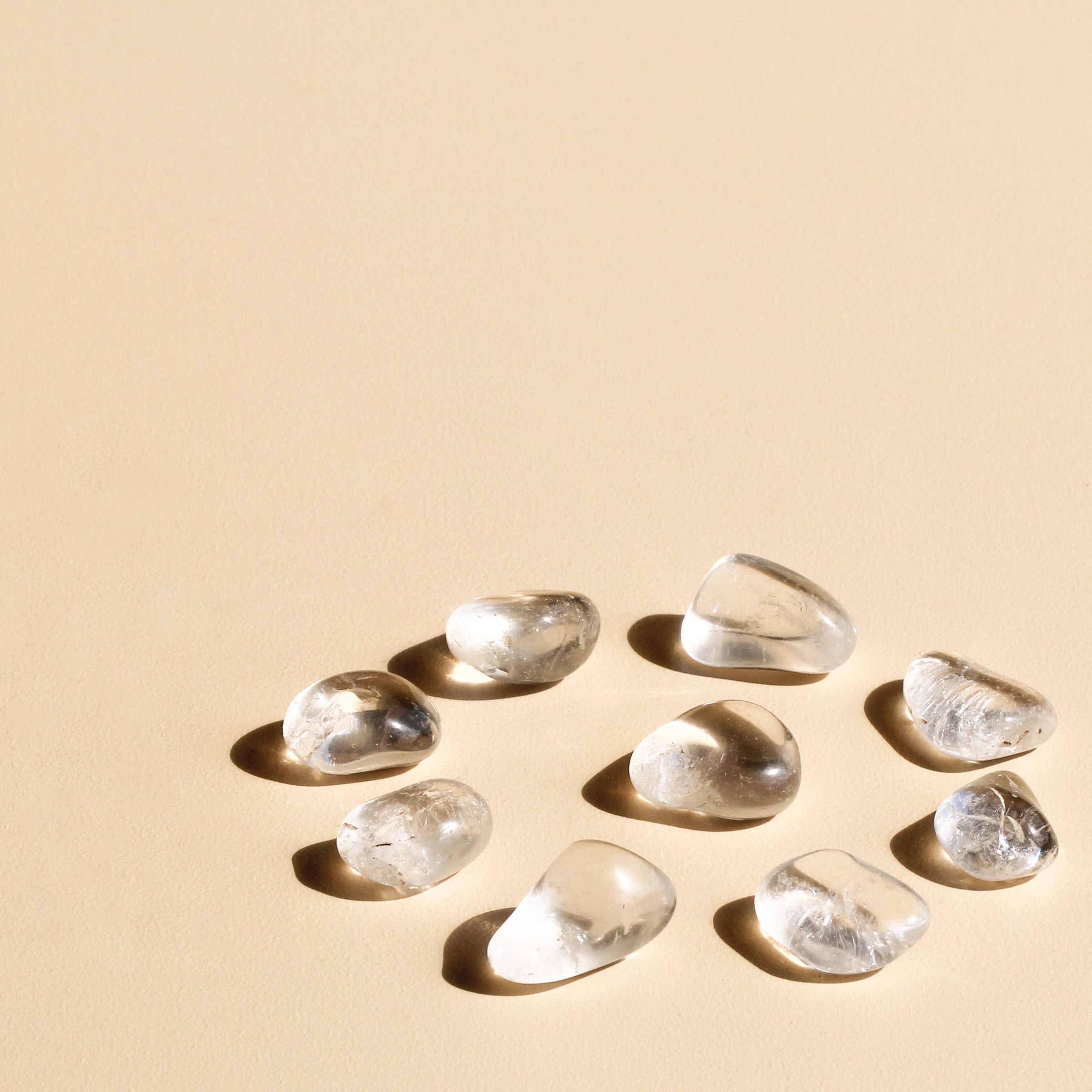 Clear Quartz Tumbles arranged in a circle with one tumble in the centre