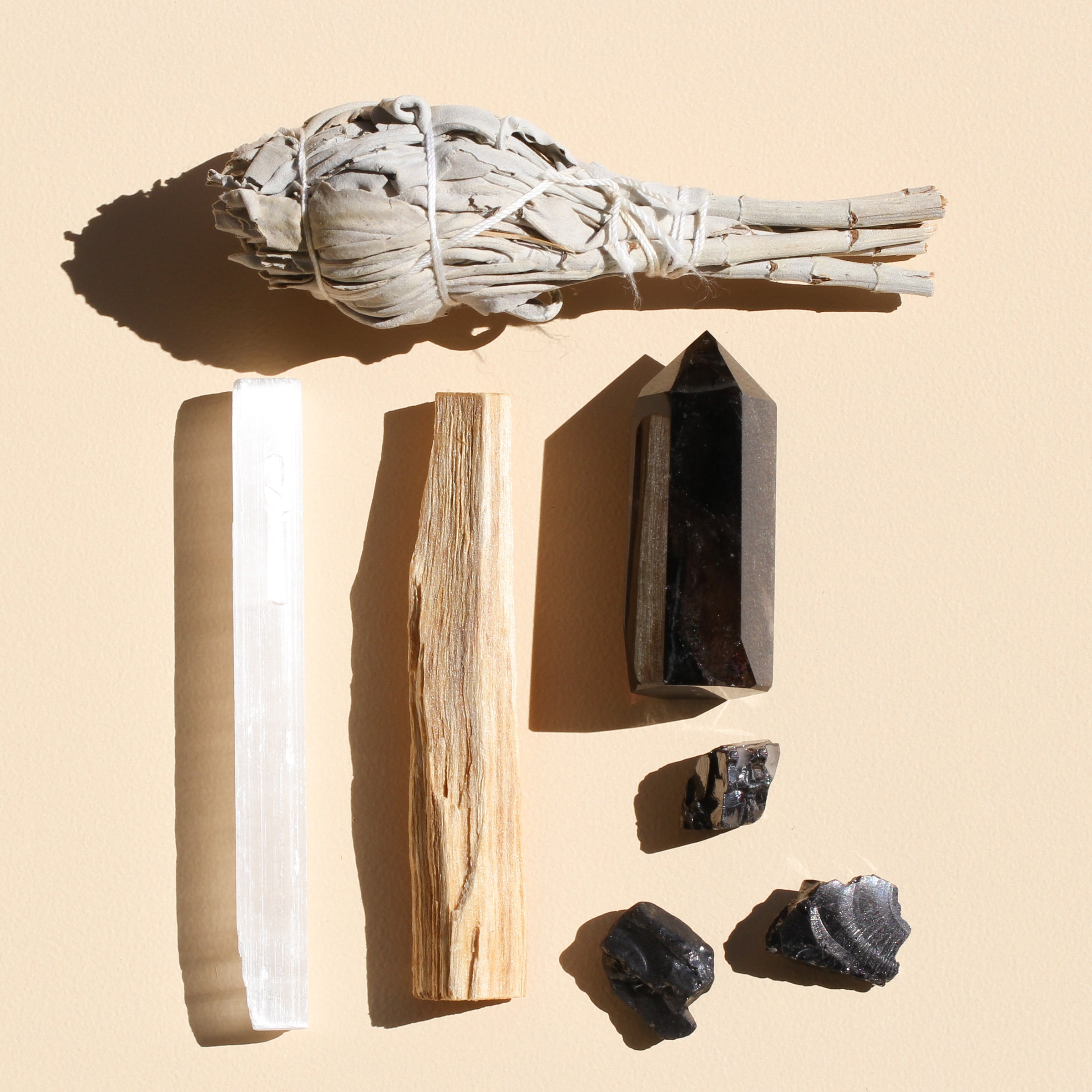 This bundle includes: 1 medium Smokey Quartz Point (5-6cm), 3 Elite Shungite pieces (1-2cm), 1 White Sage stick (10cm long), 1 Selenite stick (10cm long), and 1 Palo Santo stick (10cm)