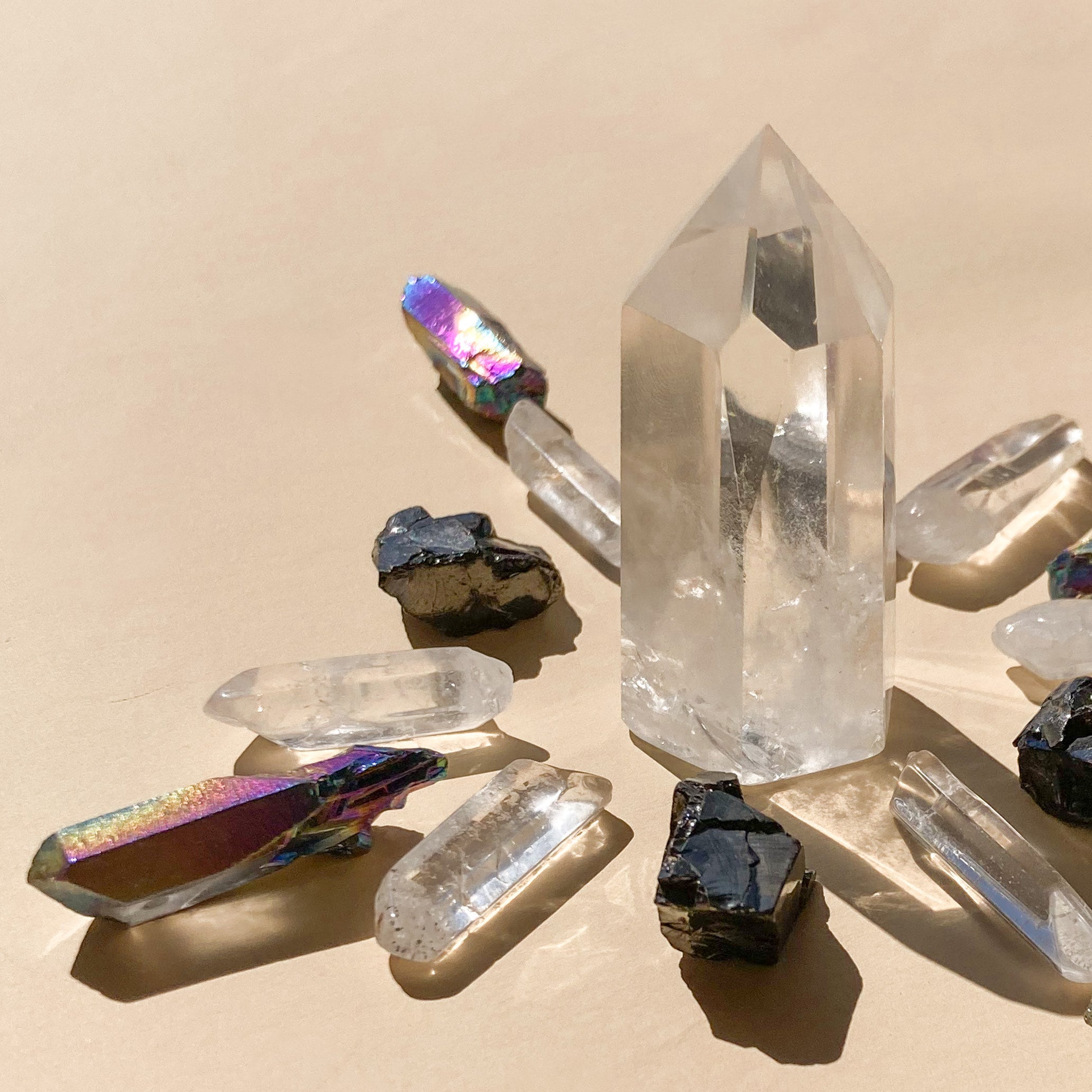 This bundle features 1 medium Clear Quartz Point (5-6cm), 6 polished Clear Quartz points, 4 Elite Shungite pieces (1-2cm), and 4 Black Rainbow Aura Quartz necklace points, blending clarity, protection, and vibrant energy