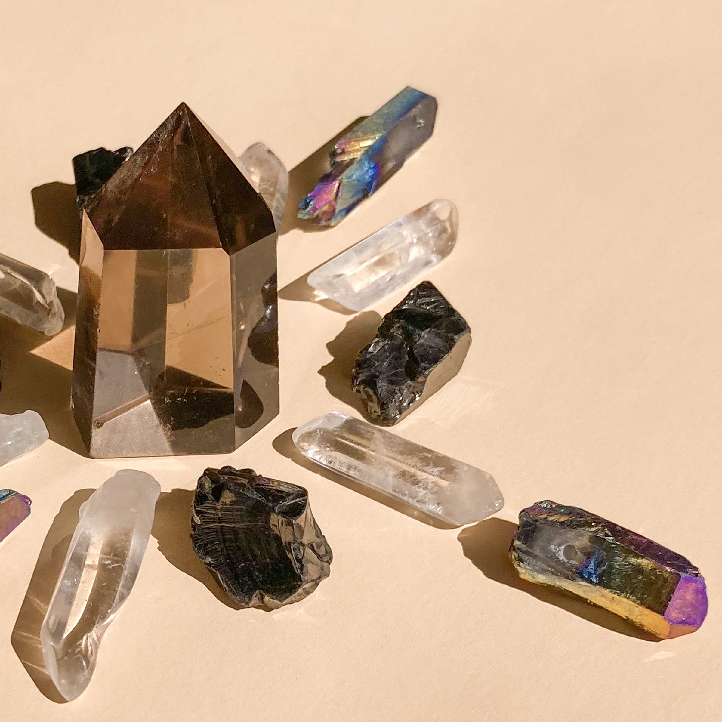 This bundle features 1 medium Smokey Quartz Point (5-6cm), 6 polished Clear Quartz points, 4 Elite Shungite pieces (1-2cm), and 4 Black Rainbow Aura Quartz necklace points, blending clarity, protection, and vibrant energy