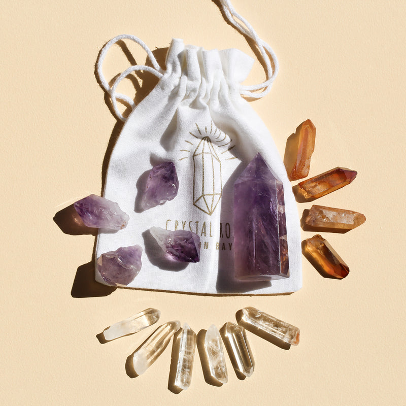 I Am Peaceful & Inspired set featuring 1 medium Amethyst Point (5-6cm), 6 polished Clear Quartz points, 4 Amethyst teeth (2-3cm), and 4 Orange Aura Quartz necklace points, combining intuition, clarity, and creativity energies, including a bag